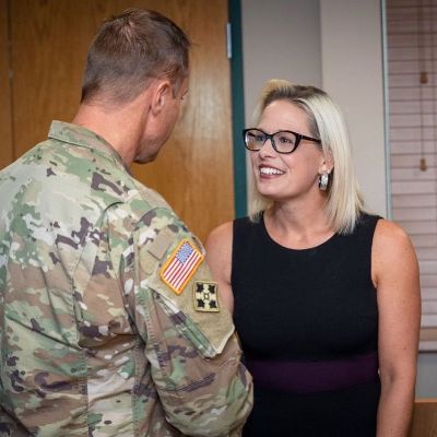 Kyrsten Sinema took a picture with an army man as they shook hands.
